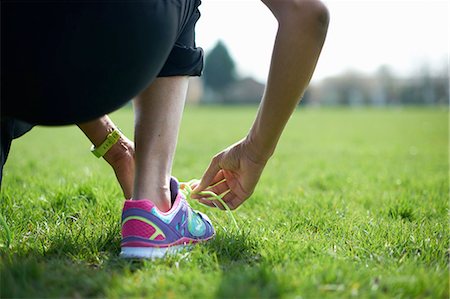 exercising park - Cropped rear view of mature woman tying trainer laces in park Stock Photo - Premium Royalty-Free, Code: 649-08144359