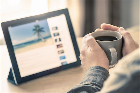 people ecommerce - Hands of man drinking coffee with digital tablet on desk Stock Photo - Premium Royalty-Free, Code: 649-08144350