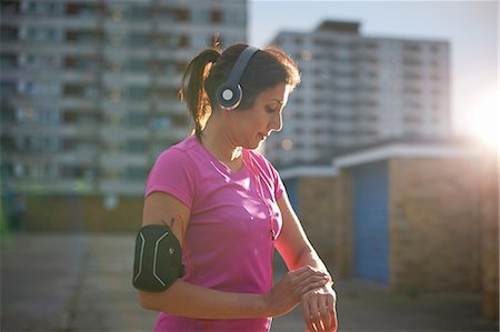 Mature female runner checking wrist watch at dusk Photographie de stock - Premium Libres de Droits, Code: 649-08144368