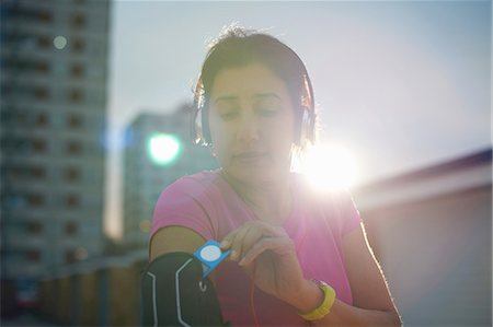 pink lifestyle - Mature female runner removing MP3 player from armband at dusk Stock Photo - Premium Royalty-Free, Code: 649-08144369