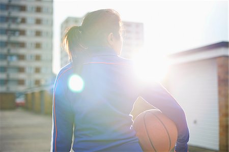 Rear view of mature female basketball player holding ball Stock Photo - Premium Royalty-Free, Code: 649-08144363