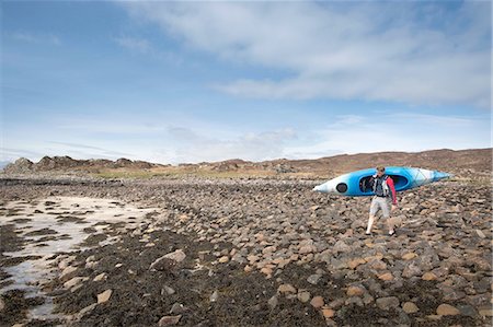 Mid adult man carrying canoe, Loch Eishort, Isle of Skye, Hebrides, Scotland Stock Photo - Premium Royalty-Free, Code: 649-08144608