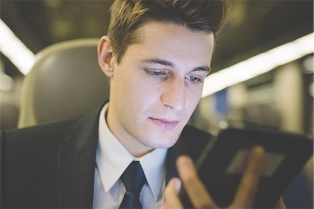 simsearch:649-08144794,k - Portrait of young businessman commuter using digital tablet on train. Stock Photo - Premium Royalty-Free, Code: 649-08144813