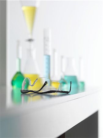 Laboratory safety glasses on lab bench with a chemical experiment in background Foto de stock - Sin royalties Premium, Código: 649-08144838