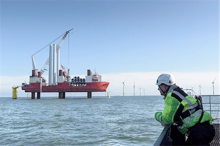 Worker looking at construction ship and offshore windfarm Stockbilder - Premium RF Lizenzfrei, Bildnummer: 649-08145109