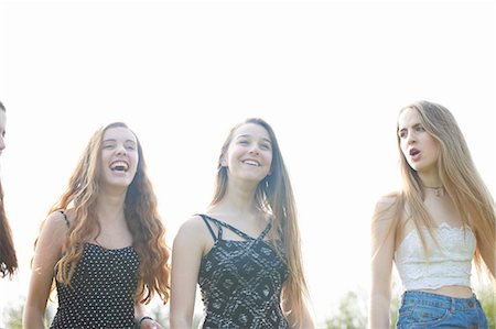 simsearch:649-08145149,k - Four teenage girls laughing and chatting in park Foto de stock - Royalty Free Premium, Número: 649-08145146