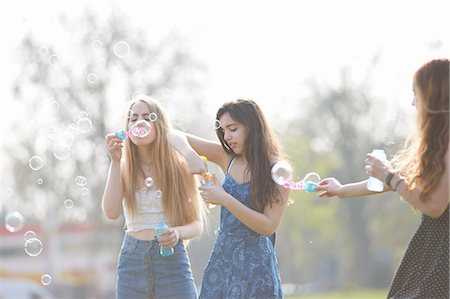 simsearch:649-07520247,k - Three teenage girls blowing bubbles with bubble wand in park Stock Photo - Premium Royalty-Free, Code: 649-08145156
