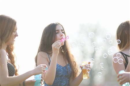 simsearch:649-08145149,k - Three teenage girls blowing bubbles in park Foto de stock - Royalty Free Premium, Número: 649-08145159
