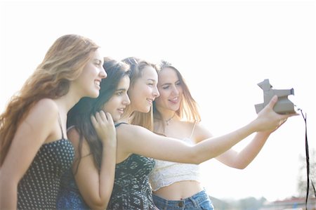 retro teenagers - Four teenage girls taking instant camera selfie in park Foto de stock - Sin royalties Premium, Código: 649-08145150