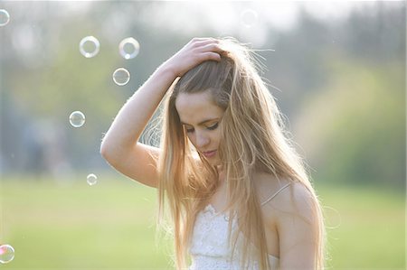 simsearch:614-08119768,k - Portrait of teenage girl with hand in hair in park Stock Photo - Premium Royalty-Free, Code: 649-08145161