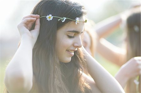 simsearch:649-08145149,k - Portrait of teenage girl putting on daisy chain headdress in park Foto de stock - Royalty Free Premium, Número: 649-08145163