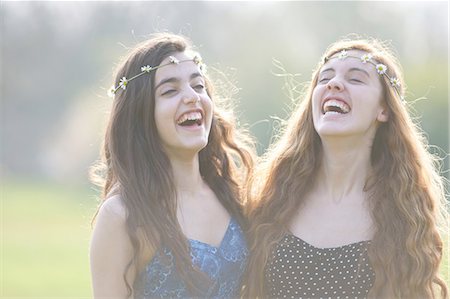 simsearch:649-08145149,k - Two teenage girls wearing daisy chain headdresses laughing in park Foto de stock - Royalty Free Premium, Número: 649-08145170