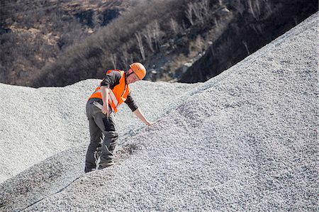 quarry worker - Quarry worker measuring on gravel mound at quarry Stock Photo - Premium Royalty-Free, Code: 649-08145195