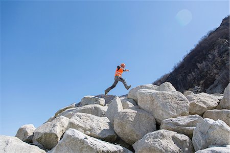 quarry worker - Worker jumping on stack of boulders at quarry Stock Photo - Premium Royalty-Free, Code: 649-08145199