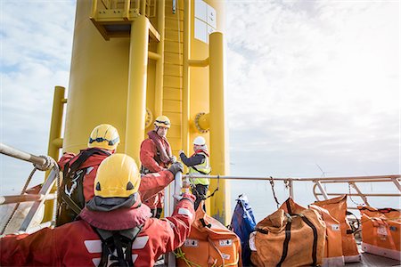 Engineers preparing to climb wind turbine on offshore windfarm Photographie de stock - Premium Libres de Droits, Code: 649-08145367