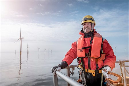 energía alternativa - Portrait of engineer on boat at offshore windfarm Foto de stock - Sin royalties Premium, Código: 649-08145374