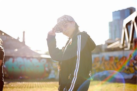 simsearch:649-07436674,k - Side view of young woman wearing baseball cap, looking at camera Fotografie stock - Premium Royalty-Free, Codice: 649-08145487