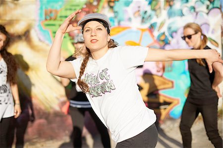 Young women breakdancing, arms raised, looking away Stock Photo - Premium Royalty-Free, Code: 649-08145501