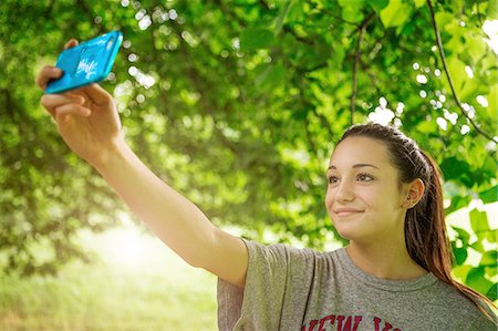 Teenage girl in park taking smartphone selfie Stock Photo - Premium Royalty-Free, Code: 649-08145567