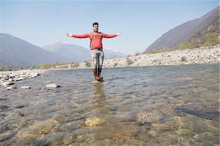 Portrait of young male hiker standing on Toce river rock, Vogogna, Verbania, Piemonte, Italy Stock Photo - Premium Royalty-Free, Code: 649-08145622