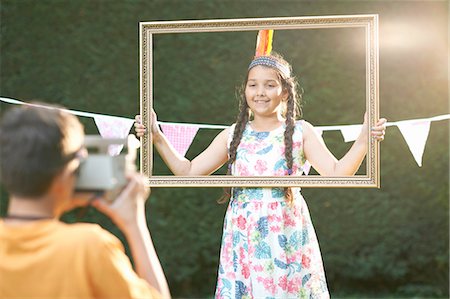 Girl looking through picture frame, having photograph taken Foto de stock - Sin royalties Premium, Código: 649-08179763