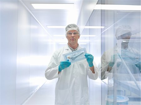 Worker holding orthopaedic hip stem replacement in clean room, portrait Stock Photo - Premium Royalty-Free, Code: 649-08179879
