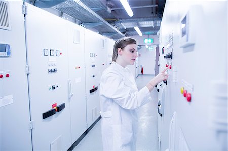 simsearch:6108-06166168,k - Young female scientist pressing button on machine control panel in technical room Photographie de stock - Premium Libres de Droits, Code: 649-08180014