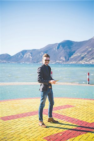 Portrait of young man on lakeside helipad, Rovato, Brescia, Italy Stock Photo - Premium Royalty-Free, Code: 649-08180046