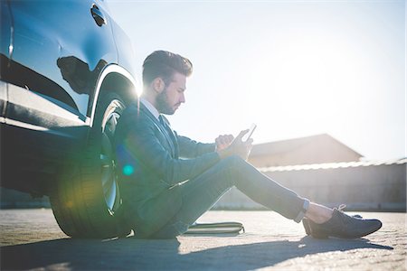 simsearch:649-08180101,k - Stylish young man sitting leaning against car using digital tablet Fotografie stock - Premium Royalty-Free, Codice: 649-08180084