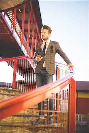 simsearch:649-08180080,k - Stylish young man with smartphone looking out from footbridge Stock Photo - Premium Royalty-Free, Code: 649-08180089