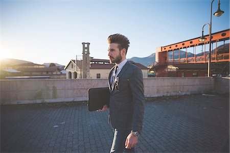 simsearch:6111-06838357,k - Young businessman carrying briefcase in urban area Photographie de stock - Premium Libres de Droits, Code: 649-08180104