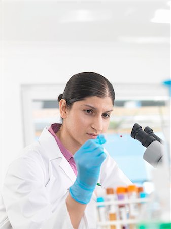 simsearch:649-07596080,k - Young woman scientist viewing blood slide during clinical testing of medical samples in a laboratory Foto de stock - Sin royalties Premium, Código: 649-08180219