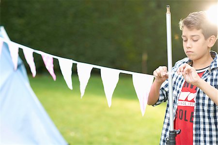 simsearch:649-08578165,k - Boy tying bunting to pole in garden Stock Photo - Premium Royalty-Free, Code: 649-08180234