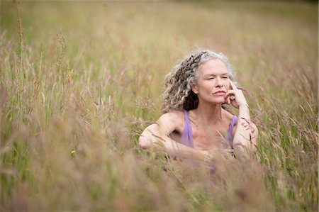 simsearch:649-07560073,k - Mature woman sitting in long grass looking away Stock Photo - Premium Royalty-Free, Code: 649-08180490