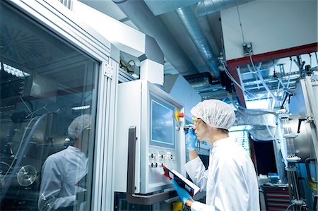 simsearch:614-06973716,k - Male scientist with notebook adjusting control panel in lab cleanroom Stock Photo - Premium Royalty-Free, Code: 649-08180595