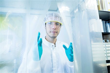 Portrait of male scientist behind plastic curtain in lab cleanroom Photographie de stock - Premium Libres de Droits, Code: 649-08180593