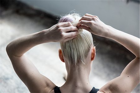 simsearch:649-08180632,k - Woman tying up hair in studio Stock Photo - Premium Royalty-Free, Code: 649-08180640