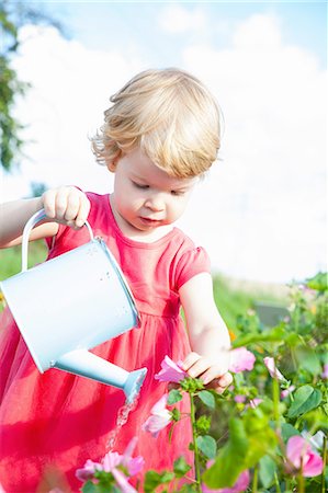 simsearch:649-08661114,k - Female toddler watering pink flowers in flower field Photographie de stock - Premium Libres de Droits, Code: 649-08180668