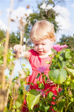 simsearch:649-08661114,k - Female toddler watering flowers in flower field Photographie de stock - Premium Libres de Droits, Code: 649-08180669
