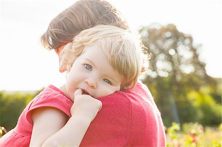 Portrait of toddler daughter resting on mothers shoulder in flower field Stock Photo - Premium Royalty-Free, Code: 649-08180676