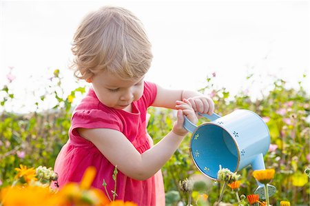 simsearch:649-08084693,k - Female toddler emptying watering can in flower field Foto de stock - Royalty Free Premium, Número: 649-08180670