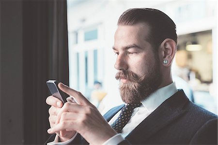 Businessman reading smartphone update in cafe Photographie de stock - Premium Libres de Droits, Code: 649-08237673