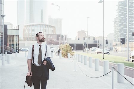 suspenders (straps worn over shoulders) - Stylish businessman carrying jacket walking in city Stock Photo - Premium Royalty-Free, Code: 649-08237688