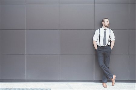 shirt and tie - Stylish businessman with hands in pockets leaning against office wall Stock Photo - Premium Royalty-Free, Code: 649-08237693