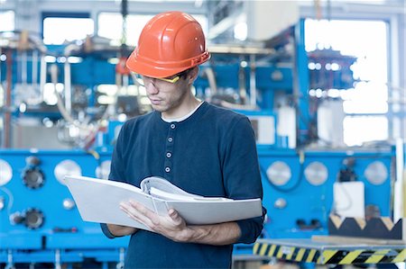 factory worker photography - Factory engineer reading machinery instruction manual Photographie de stock - Premium Libres de Droits, Code: 649-08237731