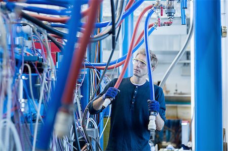 Factory technician inspecting network cables Stock Photo - Premium Royalty-Free, Code: 649-08237742