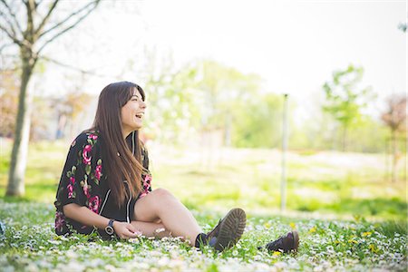 simsearch:614-06895817,k - Young woman sitting on park grass listening to earphones Photographie de stock - Premium Libres de Droits, Code: 649-08237990