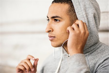 simsearch:649-08238071,k - Male runner wearing grey hoody listening to earphone music Foto de stock - Sin royalties Premium, Código: 649-08238078