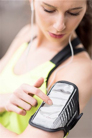 running music woman - Cropped shot of female runner choosing music on smartphone armband Photographie de stock - Premium Libres de Droits, Code: 649-08238085