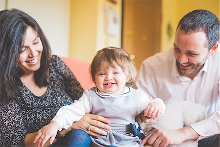 simsearch:649-08238410,k - Mid adult couple playing with toddler daughter on sofa Photographie de stock - Premium Libres de Droits, Code: 649-08238446